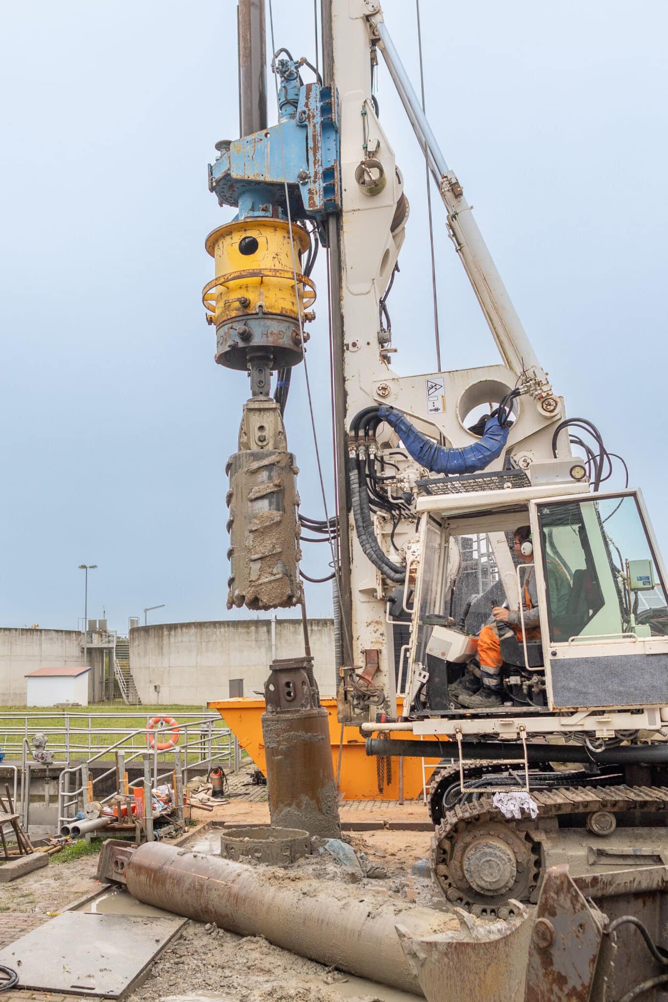 Bauarbeiter bedient Großbohrmaschine an Baustelle