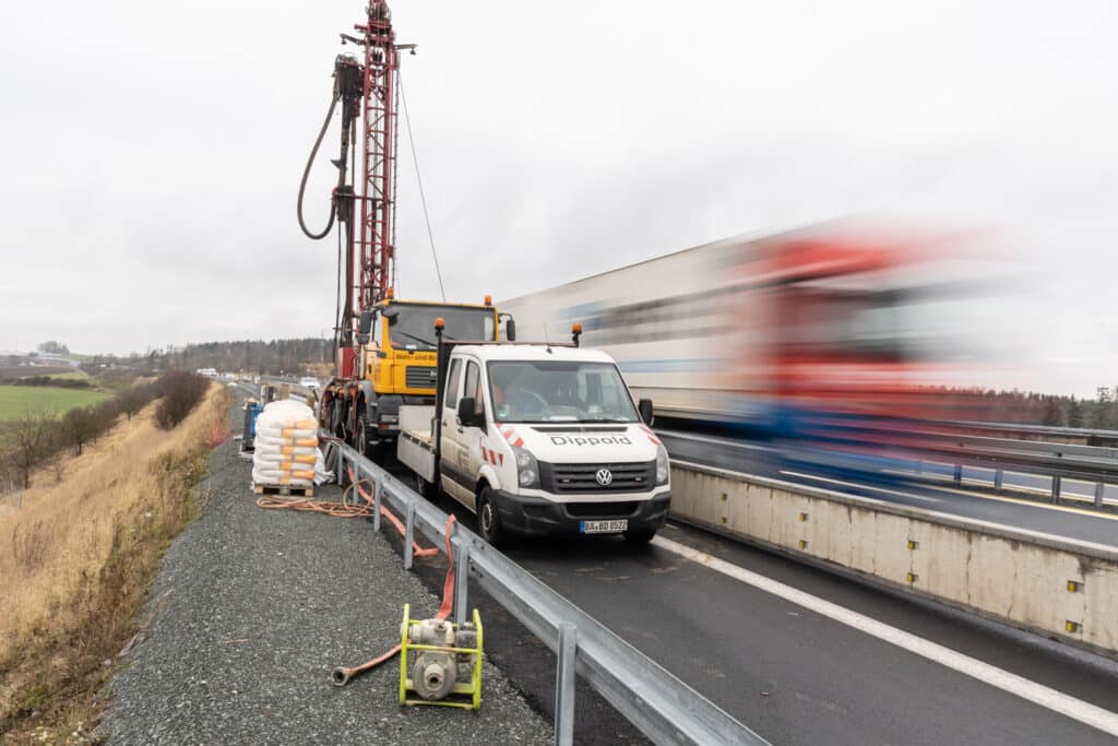 Straßenbaustelle mit LKW und Schnellstraße.